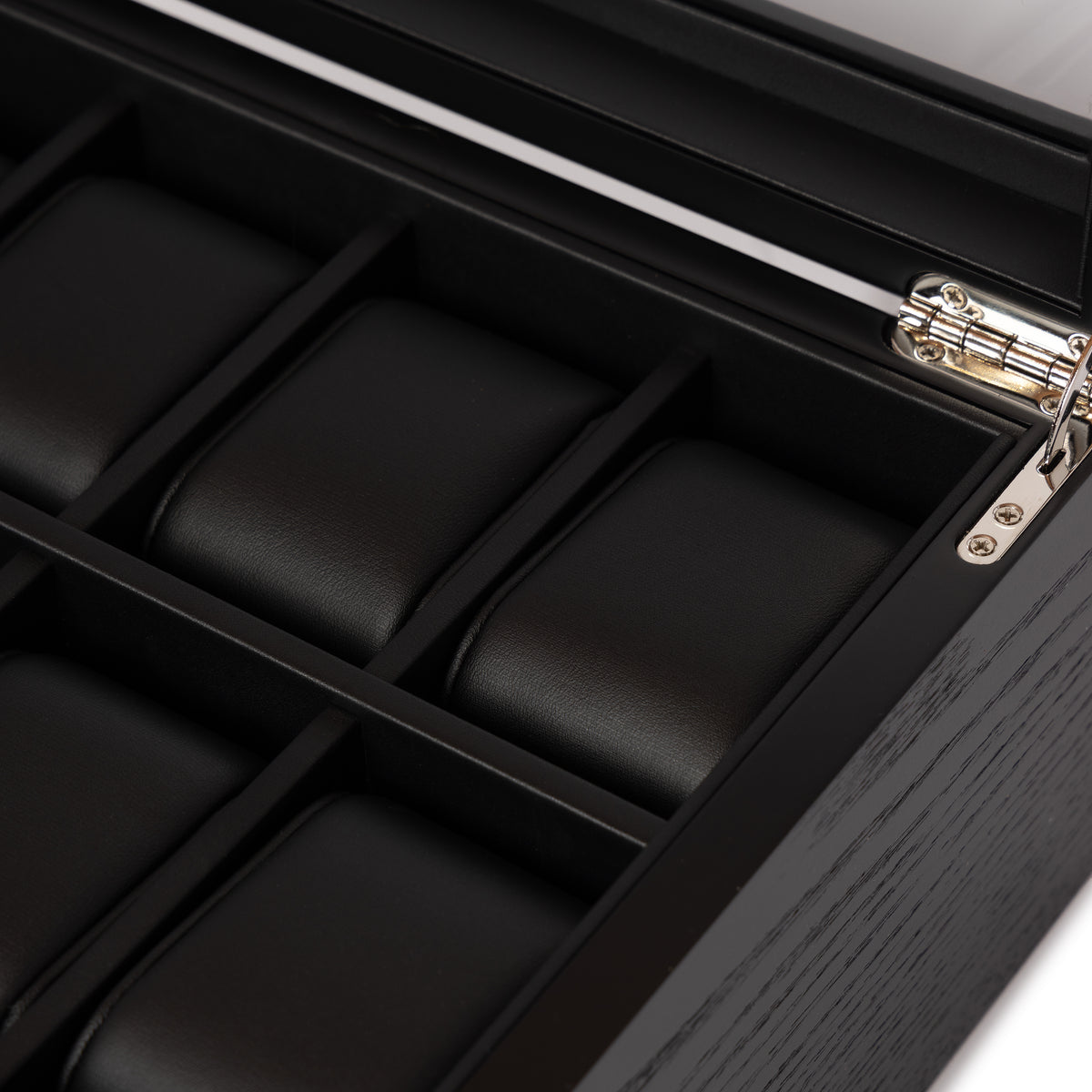 Close-up of the black leather watch cushions and polished hinge inside the Kennett 10 slot black wooden watch box