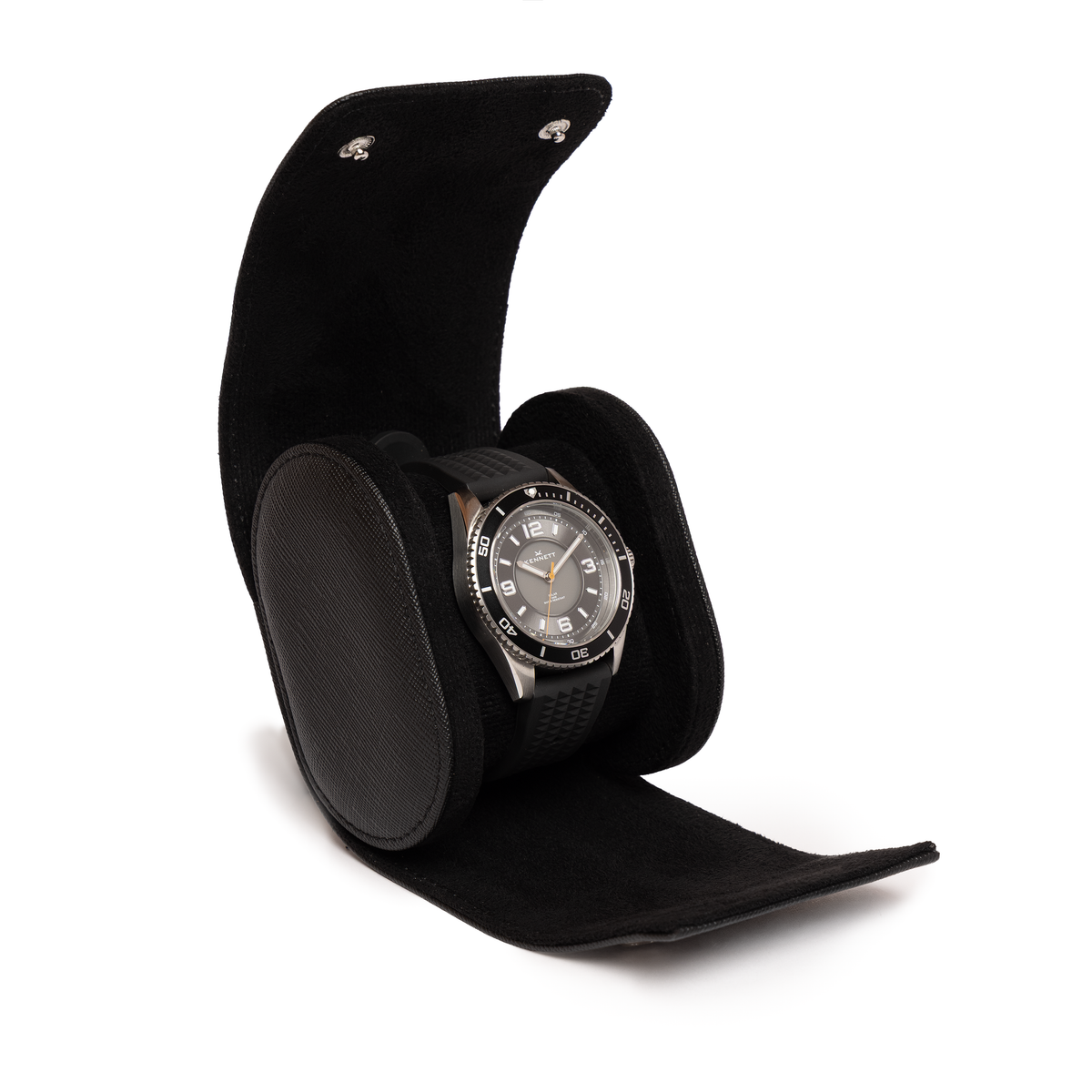 Kennett black Saffiano leather single watch roll open, holding a dive watch on a black strap around the cushion