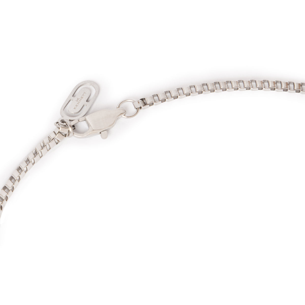 Close-up of the Kennett box chain necklace's lobster clasp and branded tag in silver tone